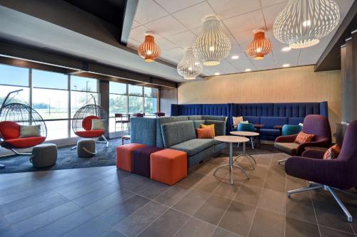 a lobby with couches and chairs and windows at Tru By Hilton Auburn, In in Auburn