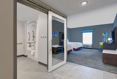 una camera d'albergo con un letto e una porta scorrevole in vetro di Hampton Inn And Suites Macclenny I-10 a Macclenny