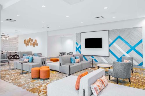 a living room with couches and a flat screen tv at Hilton Garden Inn Harlingen Convention Center, Tx in Harlingen