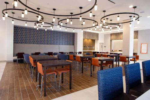 a dining room with tables and chairs under a chandelier at Hilton Garden Inn Southern Pines Pinehurst, Nc in Aberdeen