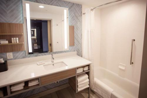 Hilton Garden Inn Southern Pines Pinehurst, Nc في Aberdeen: حمام مع حوض وحوض ومرآة