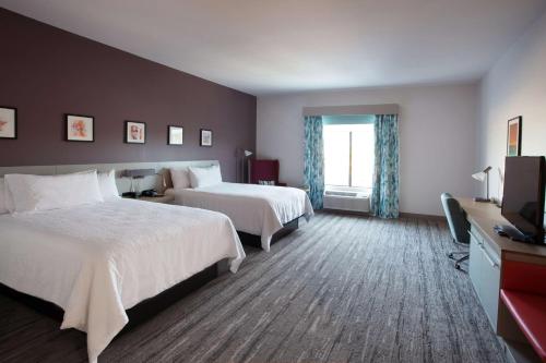 a hotel room with two beds and a television at Hilton Garden Inn Southern Pines Pinehurst, Nc in Aberdeen