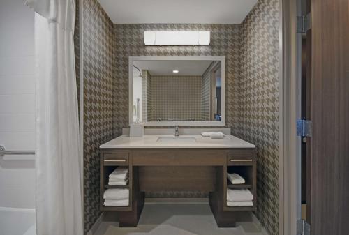 a bathroom with a sink and a mirror at Home2 Suites By Hilton Columbus in Columbus