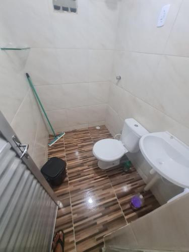 a bathroom with a toilet and a sink at Casa mobiliada para descanso e com piscina para o lazer há 5 min do aeroporto in Bayeux