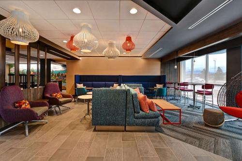 a lobby with chairs and tables and windows at Tru By Hilton Spokane Valley, Wa in Spokane Valley