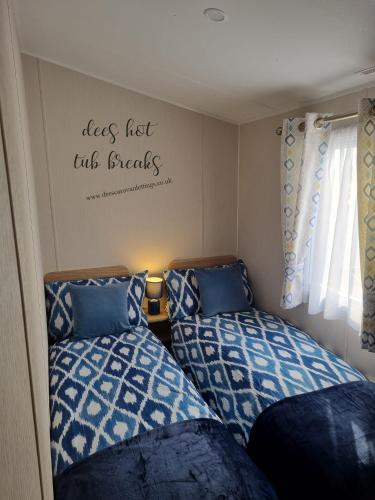 two beds in a small room with a writing on the wall at The Grange Mablethorpe Pinewood Retreat 37 in Mablethorpe