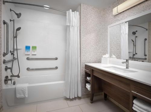 a bathroom with a tub and a sink and a shower at Home2 Suites By Hilton Fishers Indianapolis Northeast in Fishers