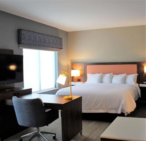 ein Hotelzimmer mit einem Bett, einem Schreibtisch und einem Schreibtisch in der Unterkunft Hampton Inn Lexington in Lexington