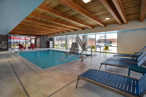a large pool with blue benches in a building at Home2 Suites Wichita Downtown Delano, Ks in Wichita