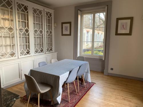 une salle à manger avec une table et des chaises bleues dans l'établissement Grande maison familiale, 5 chambres, jardin, proche 24 Heures du Mans et abbaye de Solesmes. - FR-1-410-427, à Juigné-sur-Sarthe