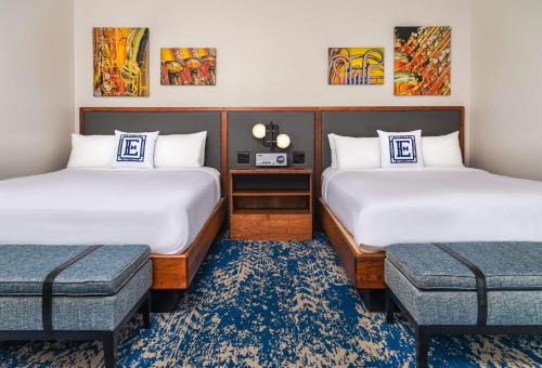 a hotel room with two beds and a table at Hotel Elkhart, Tapestry Collection By Hilton in Elkhart