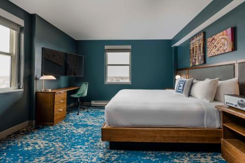 a bedroom with a bed and a desk and a television at Hotel Elkhart, Tapestry Collection By Hilton in Elkhart