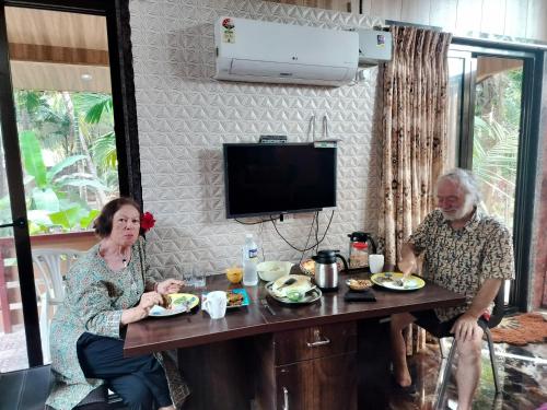 a man and woman sitting at a table with food at Seaswan resort in Alibaug