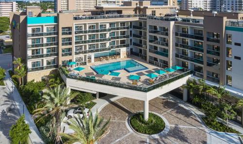 an aerial view of a building with a swimming pool at Home2 Suites By Hilton Pompano Beach Pier, Fl in Pompano Beach