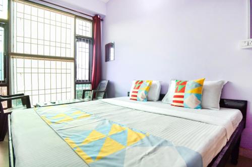 1 dormitorio con 1 cama grande y almohadas coloridas en Flagship The Alpine Homes en Solan