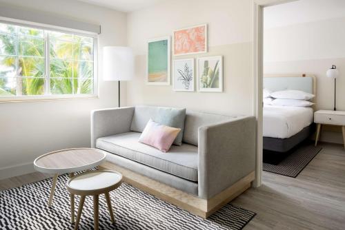 sala de estar con sofá y cama en Hampton by Hilton Grand Cayman Seven Mile Beach en George Town