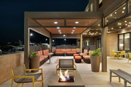 a patio with a fire pit and tables and chairs at Home2 Suites By Hilton Alamogordo White Sands in Alamogordo
