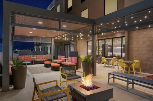 a patio with a fire pit and tables and chairs at Home2 Suites By Hilton Alamogordo White Sands in Alamogordo