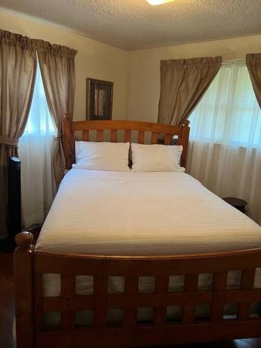 a bedroom with a wooden bed with white sheets at Home Away From Home in Columbia