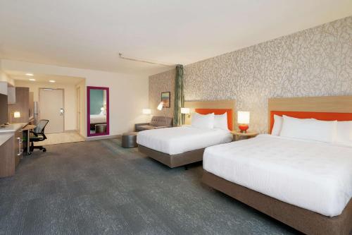 a hotel room with two beds and a desk at Home2 Suites By Hilton Alamogordo White Sands in Alamogordo