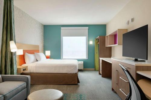 a hotel room with a bed and a flat screen tv at Home2 Suites By Hilton Alamogordo White Sands in Alamogordo
