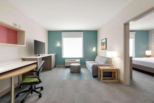 a room with a bed and a desk with a computer at Home2 Suites By Hilton Alamogordo White Sands in Alamogordo