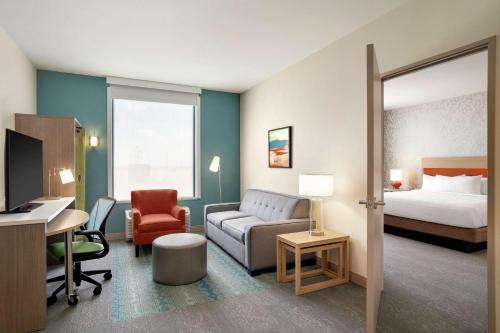 a hotel room with a bed and a living room at Home2 Suites By Hilton Alamogordo White Sands in Alamogordo