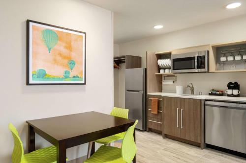 a kitchen and dining room with a table and chairs at Home2 Suites By Hilton Alamogordo White Sands in Alamogordo