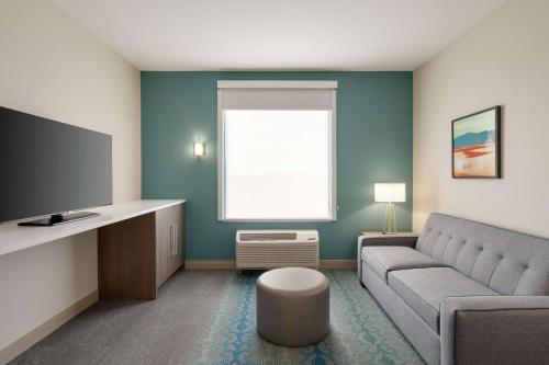 a living room with a couch and a flat screen tv at Home2 Suites By Hilton Alamogordo White Sands in Alamogordo