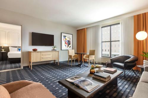 a hotel suite with a living room and a bed at 106 Jefferson Huntsville, Curio Collection by Hilton in Huntsville