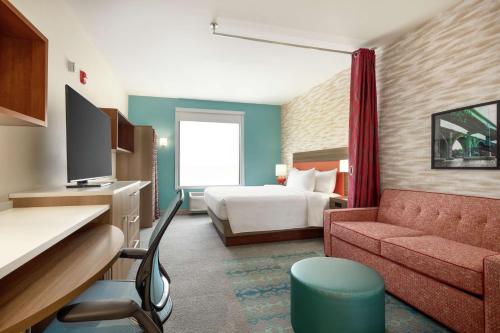 ニューブランズウィックにあるHome2 Suites by Hilton New Brunswick, NJのベッドとソファ付きのホテルルーム