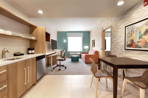 a kitchen and living room with a table and chairs at Home2 Suites by Hilton New Brunswick, NJ in New Brunswick