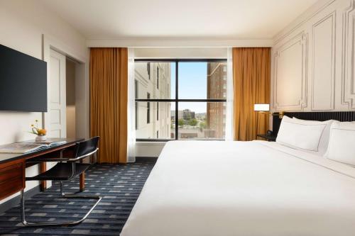 a hotel room with a large bed and a desk at 106 Jefferson Huntsville, Curio Collection by Hilton in Huntsville