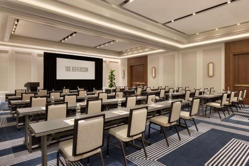 a conference room with tables and chairs and a screen at 106 Jefferson Huntsville, Curio Collection by Hilton in Huntsville