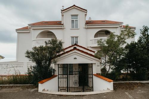 una casa blanca con una puerta delante de ella en Villa Bellevue en Novi Vinodolski