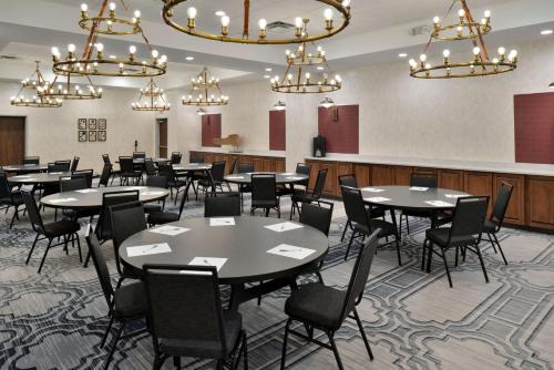 a dining room with tables and chairs and chandeliers at Hampton Inn & Suites Greensboro Downtown, Nc in Greensboro