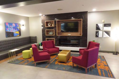 a waiting room with chairs and a flat screen tv at Best Western Heritage Inn & Suites in Broussard