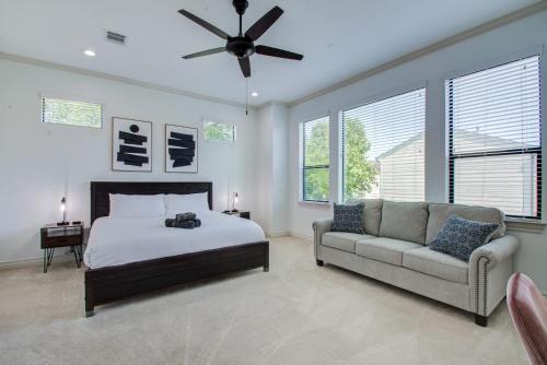 ein Schlafzimmer mit einem Bett, einem Sofa und Fenstern in der Unterkunft 3 BR 3 5 Bath private pool in Houston