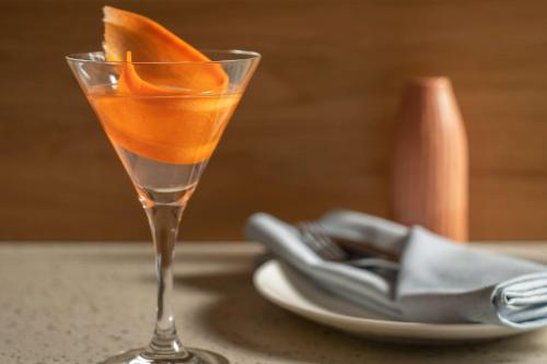 a glass with an orange object in it on a table at Hotel Marcel New Haven, Tapestry Collection By Hilton in New Haven