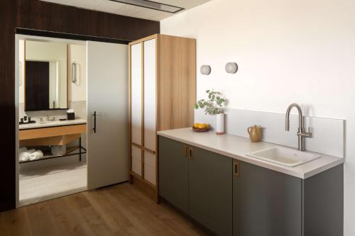 a kitchen with a sink and a mirror at Hotel Marcel New Haven, Tapestry Collection By Hilton in New Haven