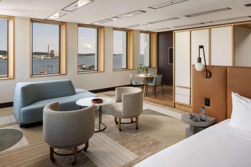 a hotel room with a bed and a couch and chairs at Hotel Marcel New Haven, Tapestry Collection By Hilton in New Haven