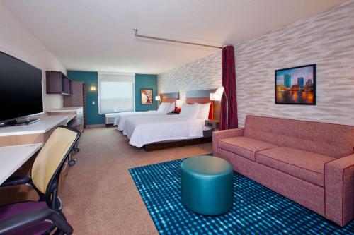 ein Hotelzimmer mit einem Bett und einem Sofa in der Unterkunft Home2 Suites By Hilton Grand Rapids South in Byron Center