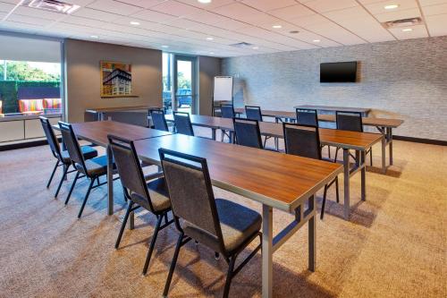a conference room with wooden tables and chairs at Home2 Suites By Hilton Grand Rapids South in Byron Center