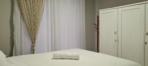 Una cama blanca con una toalla encima. en Quarto Luz en Jaraguá do Sul