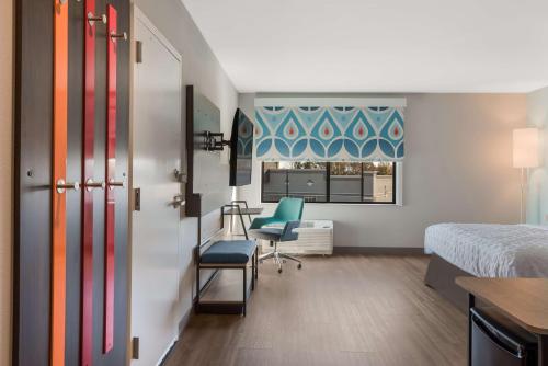 a hospital room with a bed and a desk and a chair at Tru By Hilton Greensboro, Nc in Greensboro