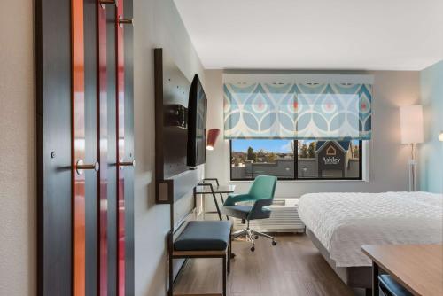 um quarto de hotel com uma cama e duas cadeiras e uma janela em Tru By Hilton Greensboro, Nc em Greensboro