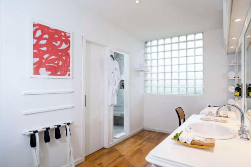 La salle de bains est pourvue d'un lavabo et d'une peinture rouge sur le mur. dans l'établissement Royal Palm Galapagos, Curio Collection Hotel by Hilton, à Bellavista