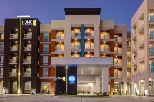 a large apartment building with a hotel sign in front at Tru By Hilton Galveston, Tx in Galveston
