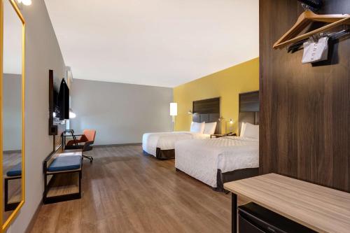 a hotel room with two beds and a television at Tru By Hilton Galveston, Tx in Galveston