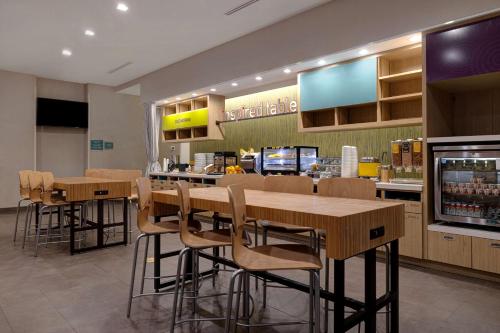 a restaurant with wooden tables and chairs and a counter at Home2 Suites Galveston, Tx in Galveston
